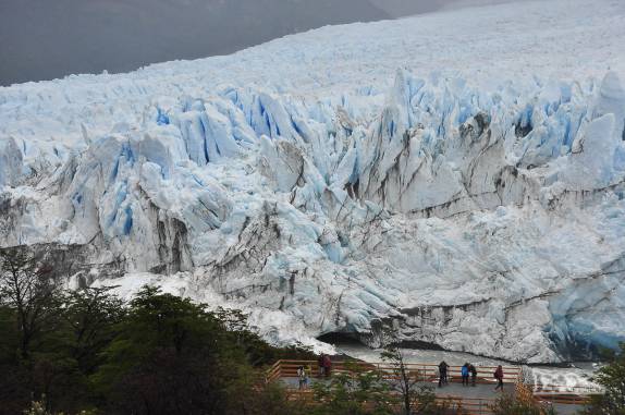 Turistas ficam minúsculos perto das paredes de gelo do glaciar Perito Moreno, no parque Nacional Los Glaciares, região de El Calafate, no sul da Argentina